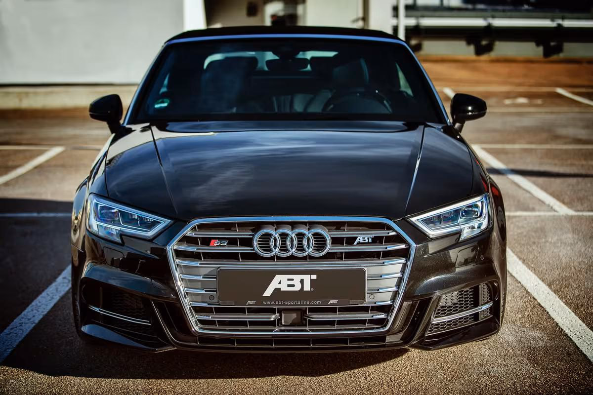 Schwarzer ABT Audi S3 mit Frontansicht auf einem Parkplatz.