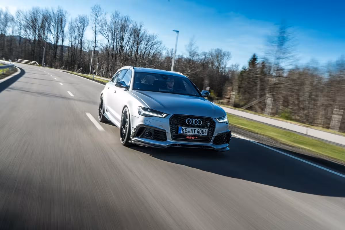 Silberner Audi RS6 Avant fährt mit hoher Geschwindigkeit auf einer Landstraße.