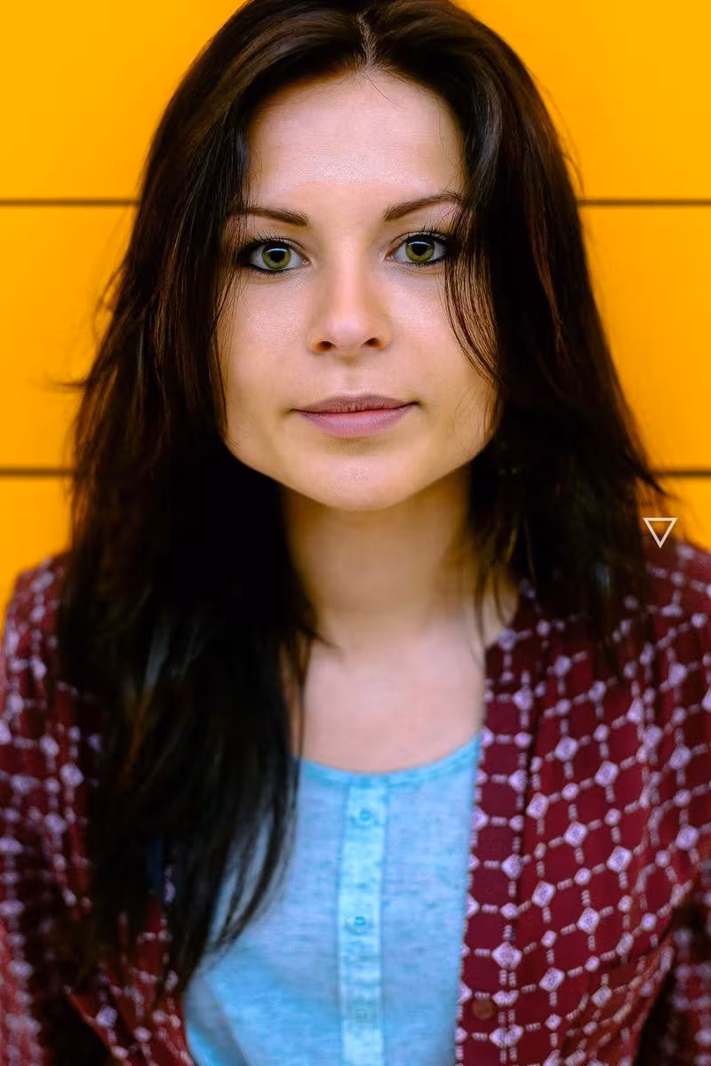 Lifestyle: Porträt einer Frau mit dunklem Haar vor gelbem Hintergrund
