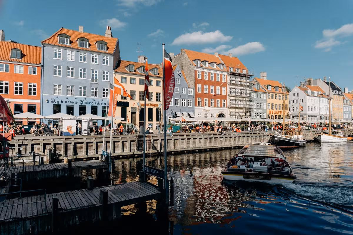 Copenhagen: Bunte Häuser am Hafen mit Booten und Menschen in Kopenhagen