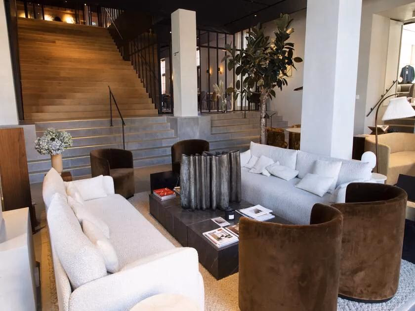 Wohnbereich mit Sofas, Sesseln und Treppe im The Audo Showroom
