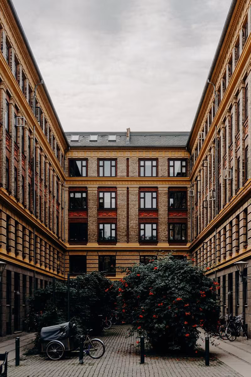 Copenhagen: Historischer Ziegelbau mit Innenhof, Rosenbüschen und gepflasterter Fläche