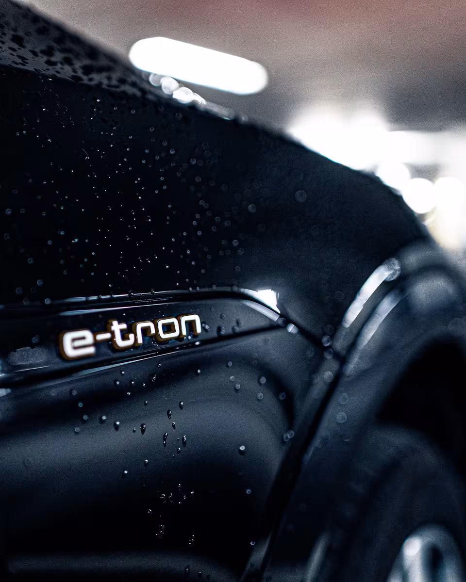 Close-up of a wet black E-Tron with visible lettering