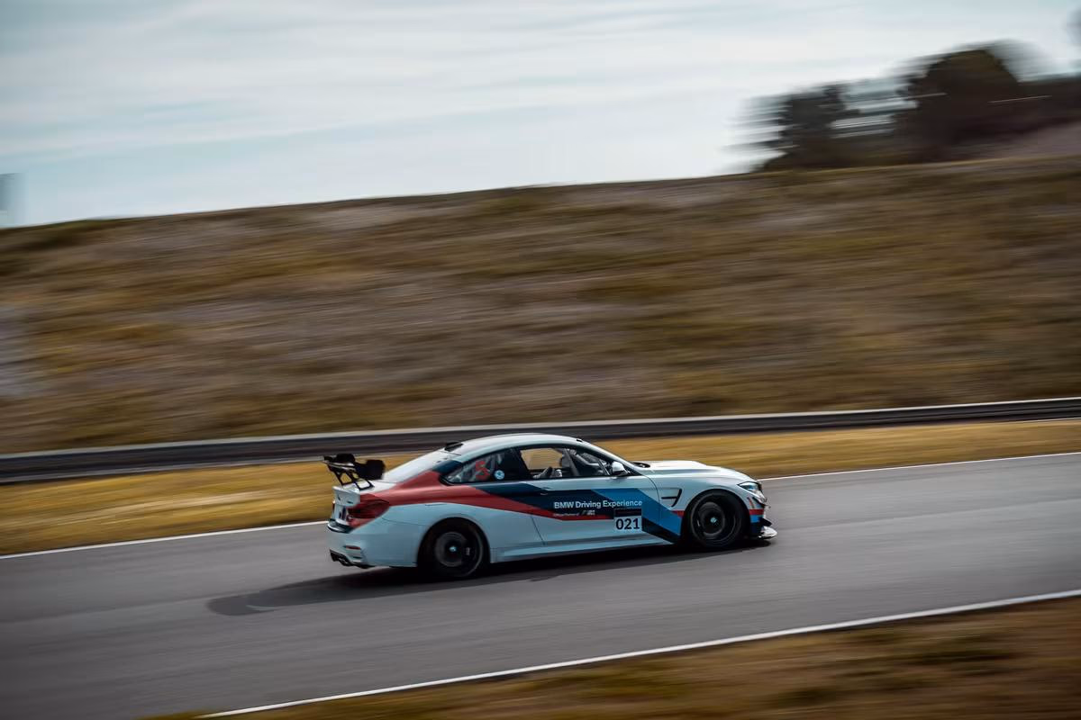 BMW M4 Rennwagen mit „Driving Experience“-Livery und Startnummer 021 auf der Strecke.