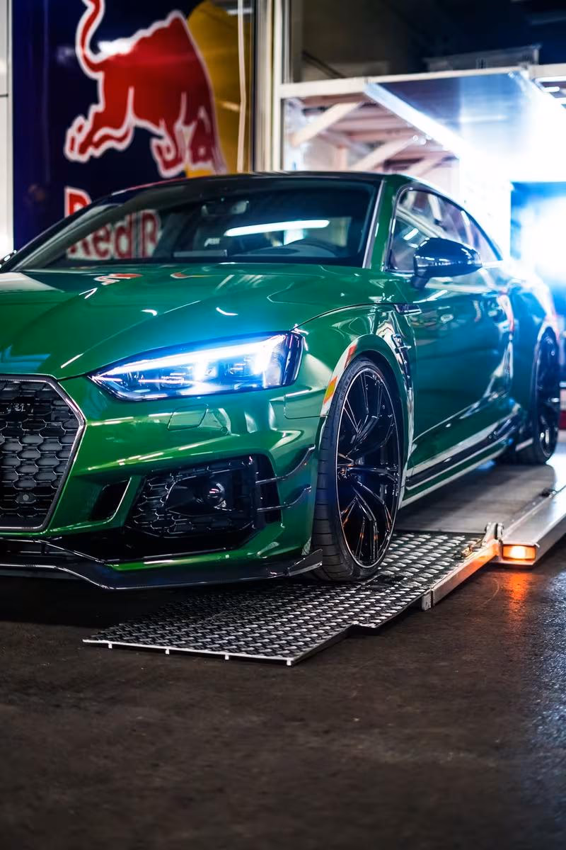 ABT: Grüner ABT Audi RS5 Coupé vor Red-Bull-Logo im Innenraum.
