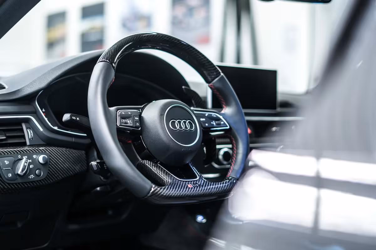 Audi-Cockpit mit Carbonlenkrad, Touchscreen und Sportpedalen im Detail