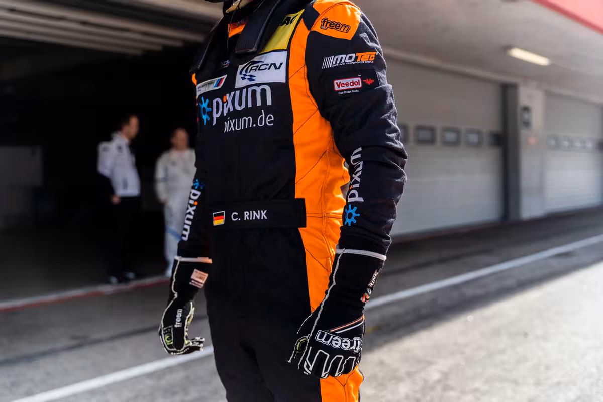 BMW Motorsport: Rennoverall mit Sponsorenlogos und Handschuhen vor der Boxengasse