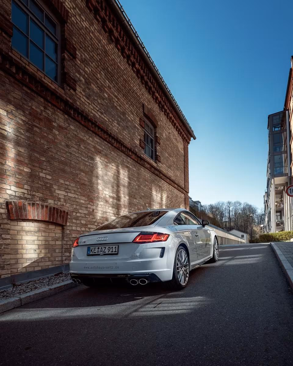 Silberner Audi RS5 Coupé mit Folierung vor roter Ziegelwand