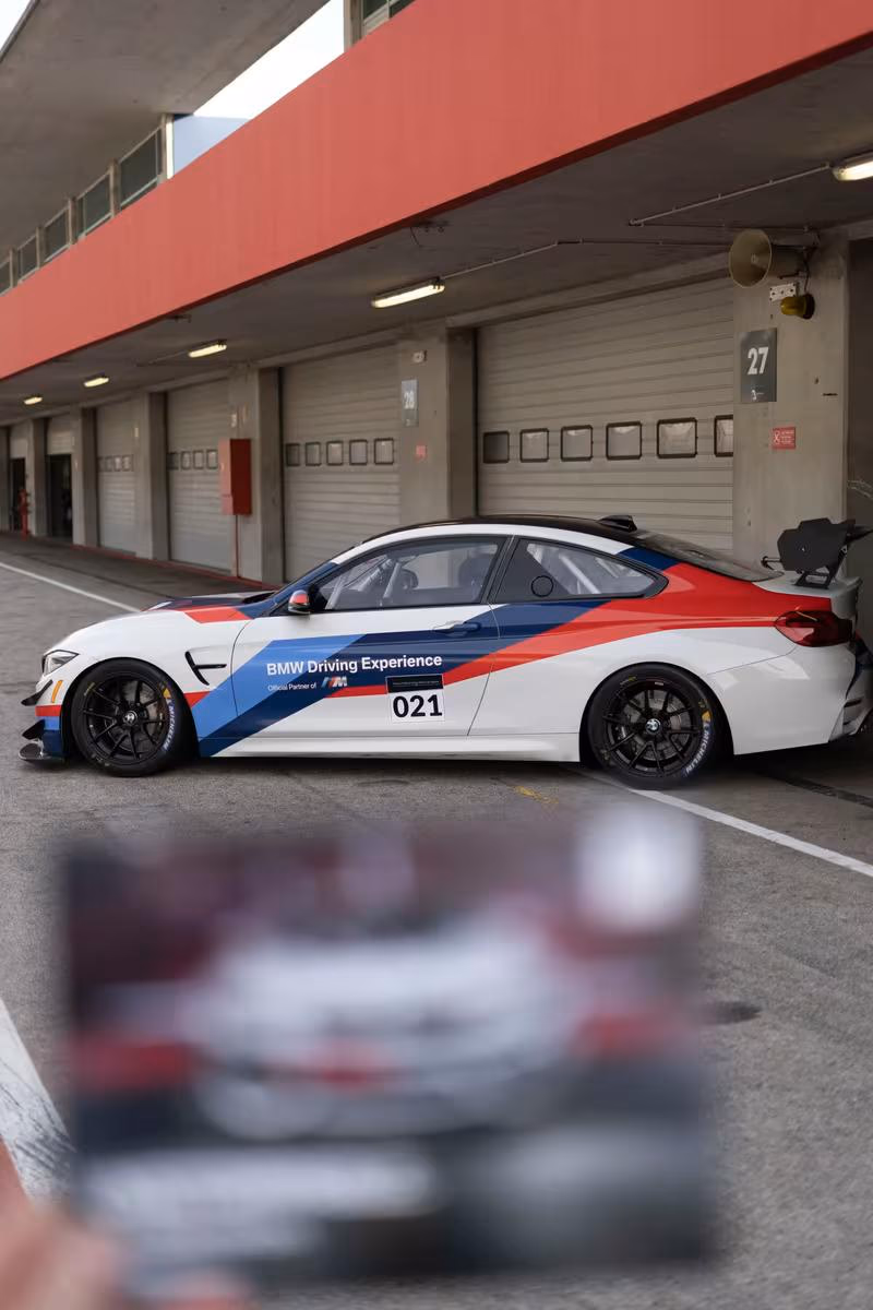 BMW Motorsport: BMW M4 Rennwagen mit M-Farben und Startnummer 021 im Boxenbereich