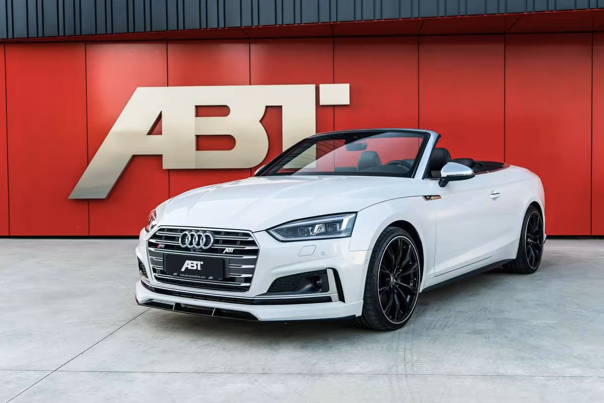 Weißer Audi ABT Cabriolet vor roter Wand mit großem ABT-Logo