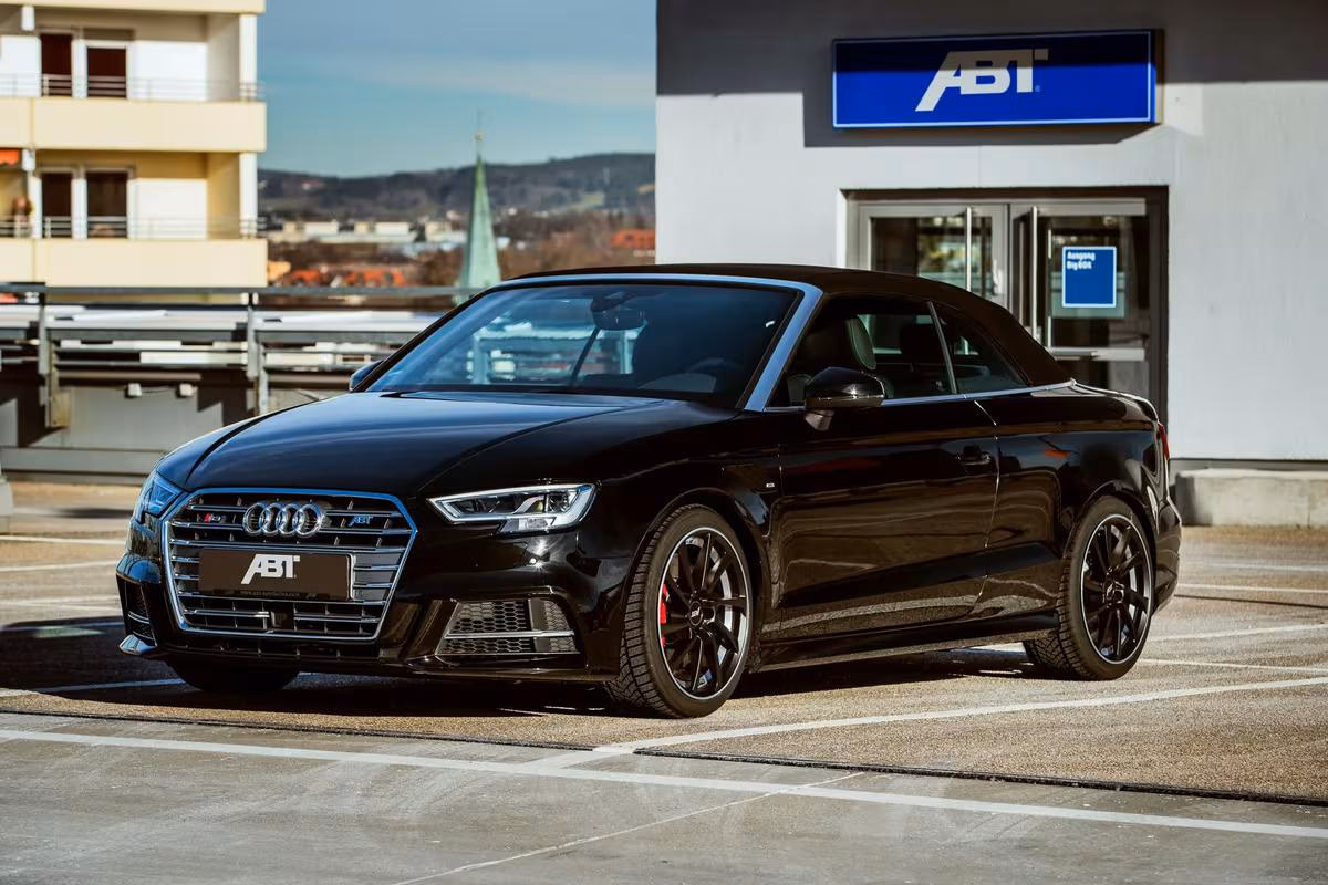 Schwarzer Audi A5 Cabriolet mit ABT-Logo vor ABT-Gebäude