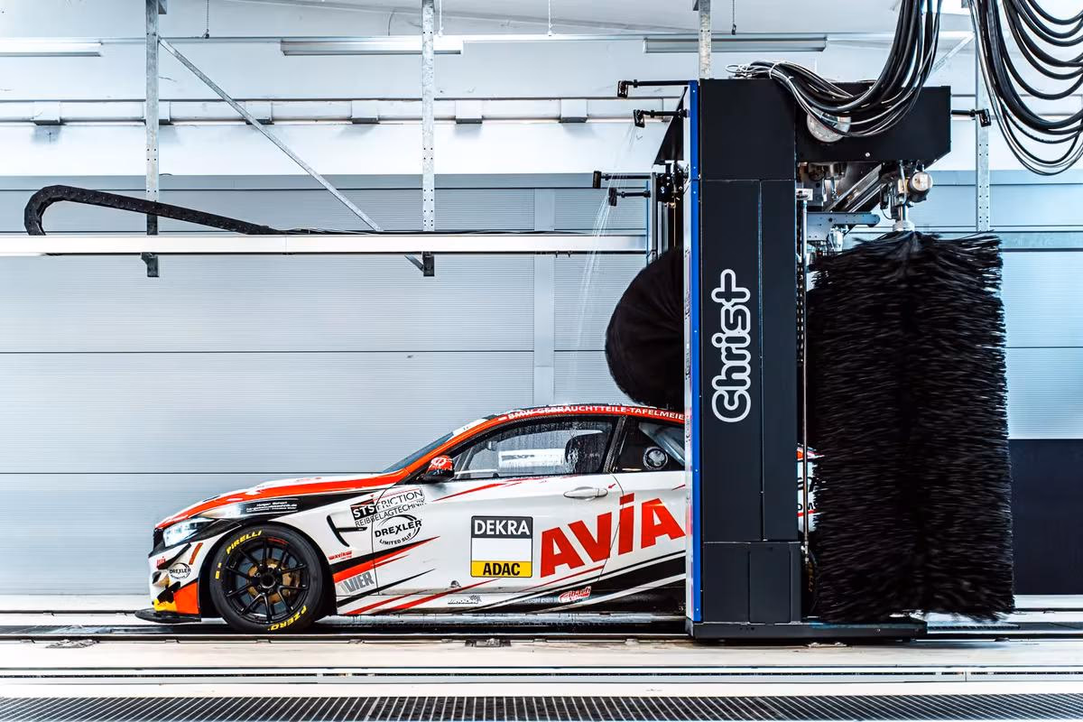 Rennwagen mit Avia-Lackierung wird in einer Christ-Waschanlage gereinigt.