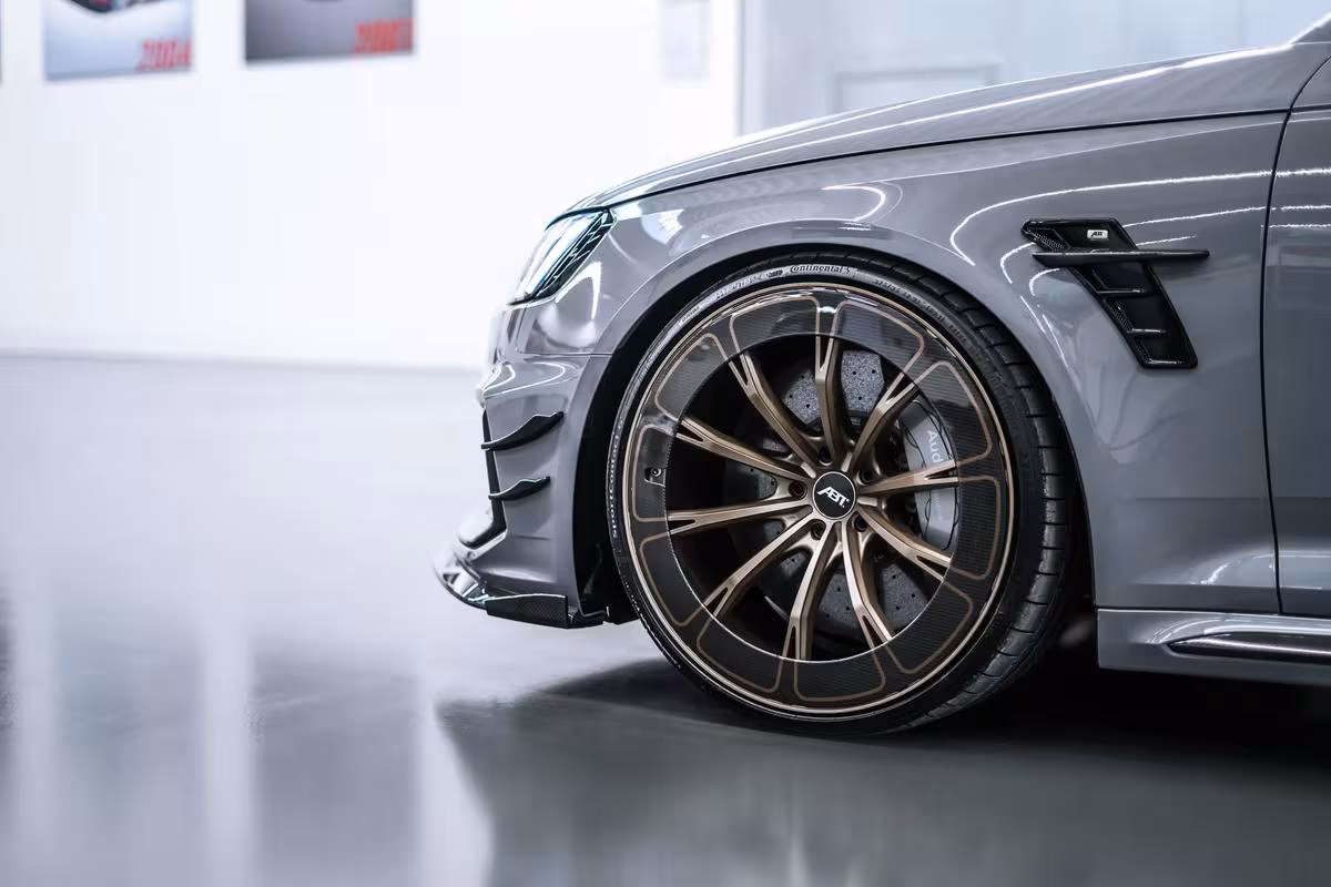 Audi: Grauer Sportwagen mit bronzefarbenen AST-Felgen und Carbon-Details im Studio.