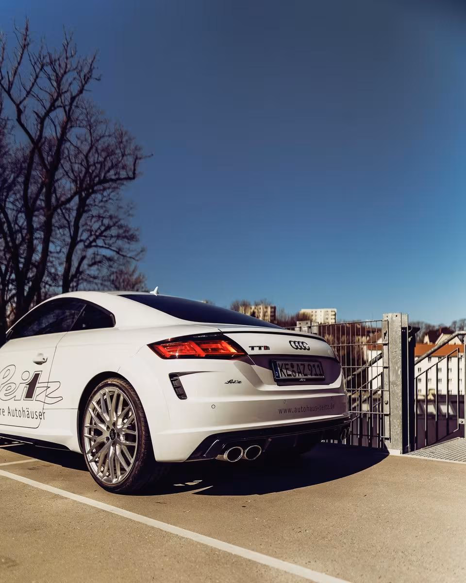 Weißer Audi TT RS Coupé mit Seitz-Branding auf Parkdeck