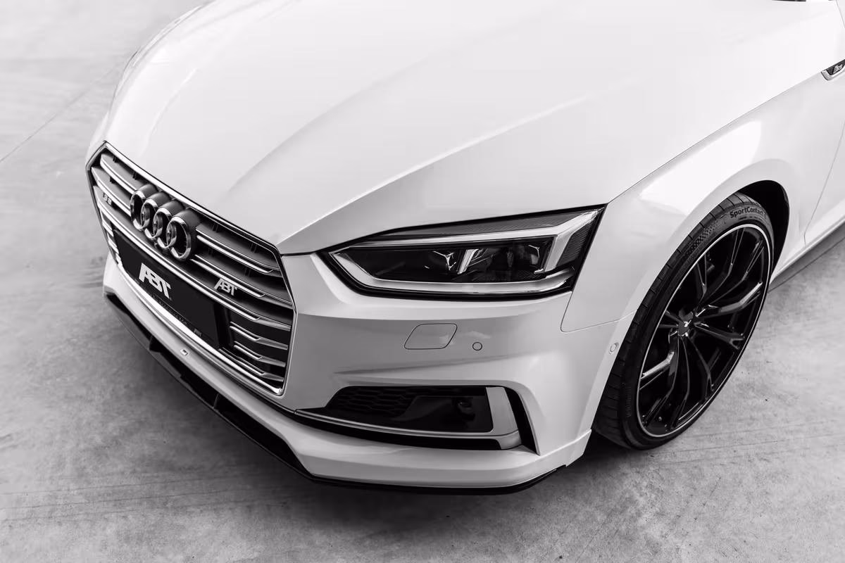 Frontansicht eines weißen Audi mit ABT-Tuner-Logo und schwarzem Sportfelge.