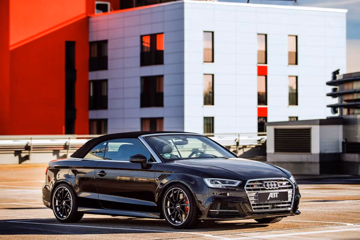 Schwarzer Audi TT Roadster mit ABT-Modifikationen vor modernem Gebäude