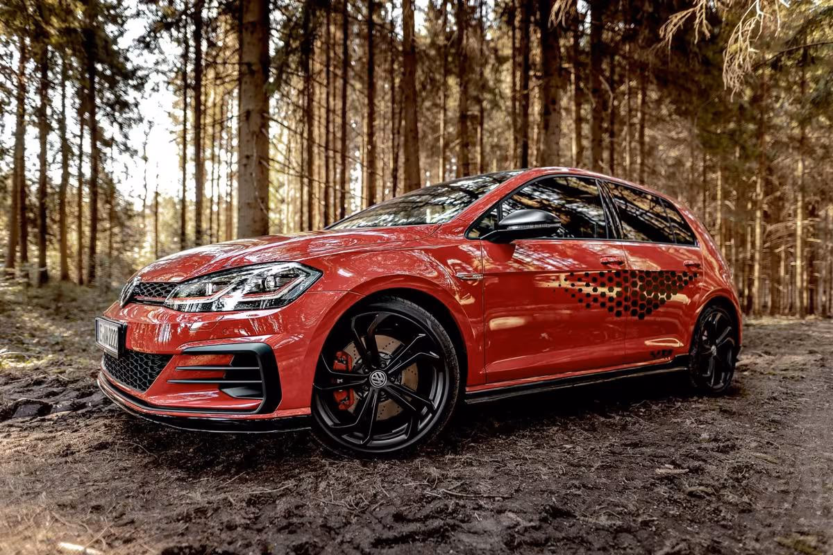 Volkswagen: Roter VW Golf GTI mit schwarzem Frontspoiler und Felgen im Wald