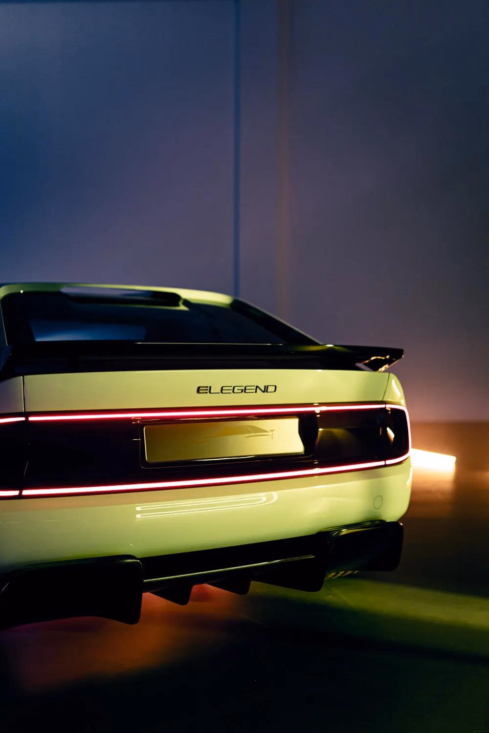 Rückansicht eines weißen E-Legend-Autos mit roter LED-Lichtleiste und Schriftzug „ELEGEND“.