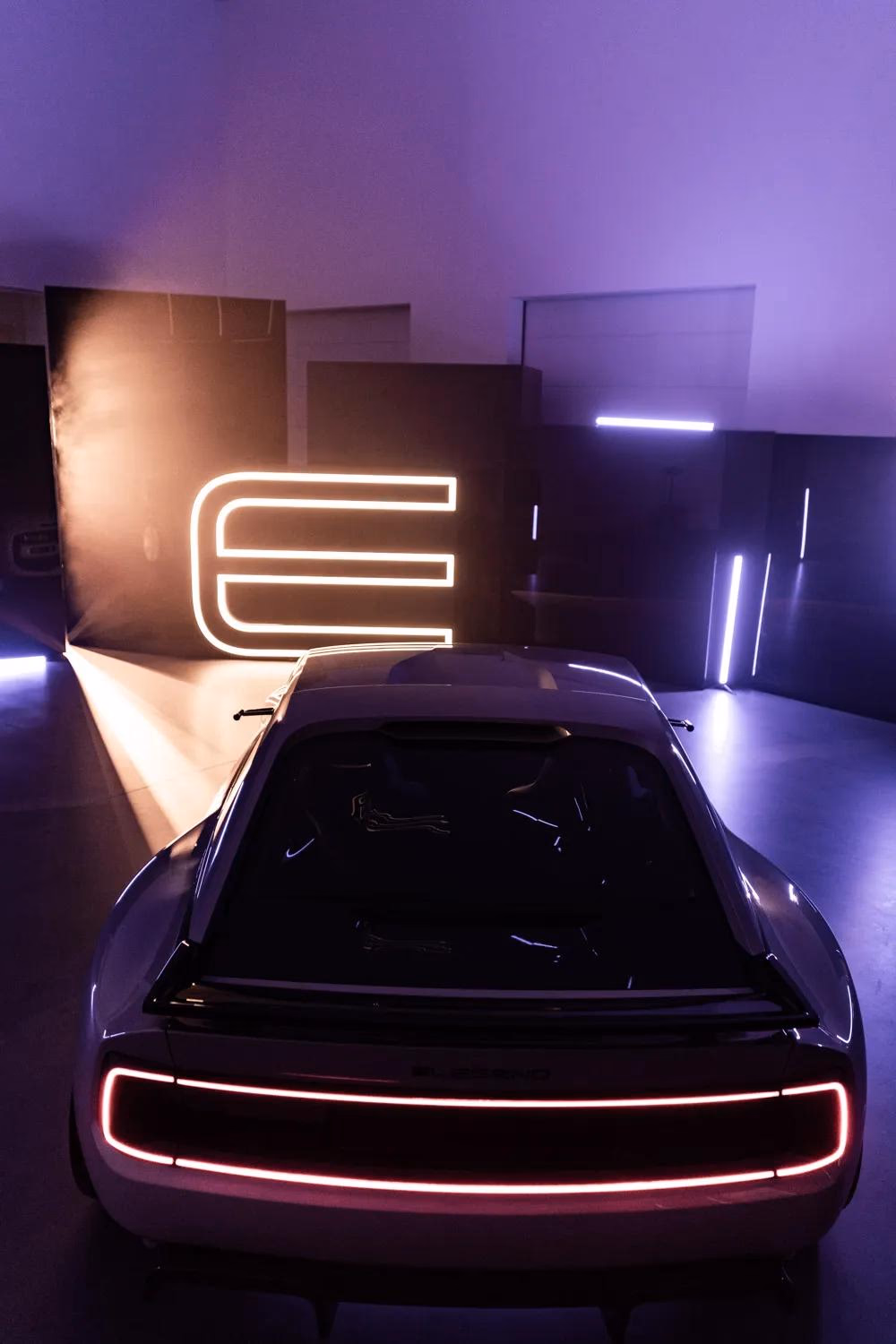 E-Legend Concept Car mit Leuchtringen vor Neon-Logo in lila Studio