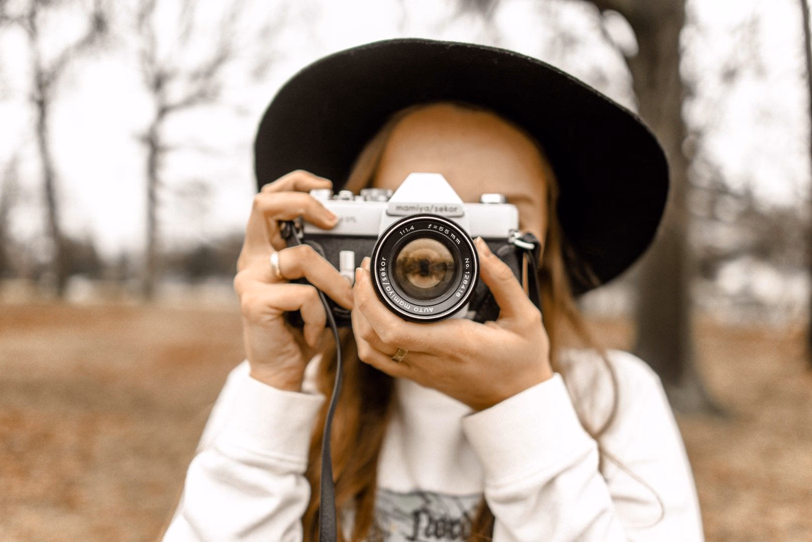 Person mit Hut fotografiert mit einer Mamiya-Spiegelreflexkamera im Freien.