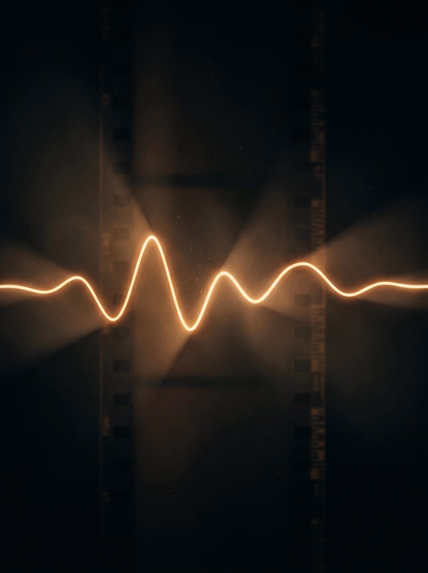 Leuchtende Wellenlinie vor dunklem Filmstreifen mit Lichtkegeln