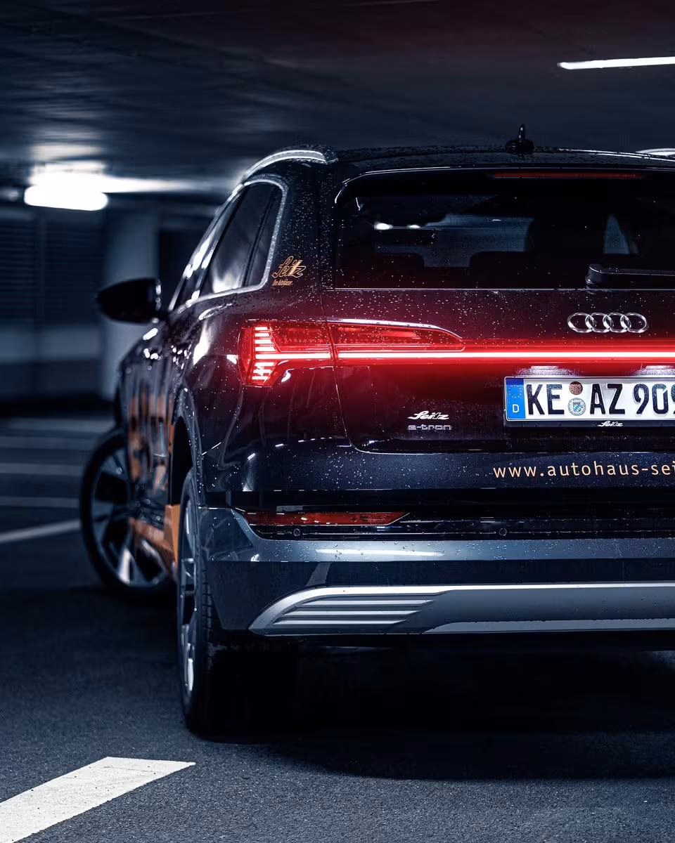 Rear view of a wrapped Audi e-tron with “Seitz” branding in a parking garage.