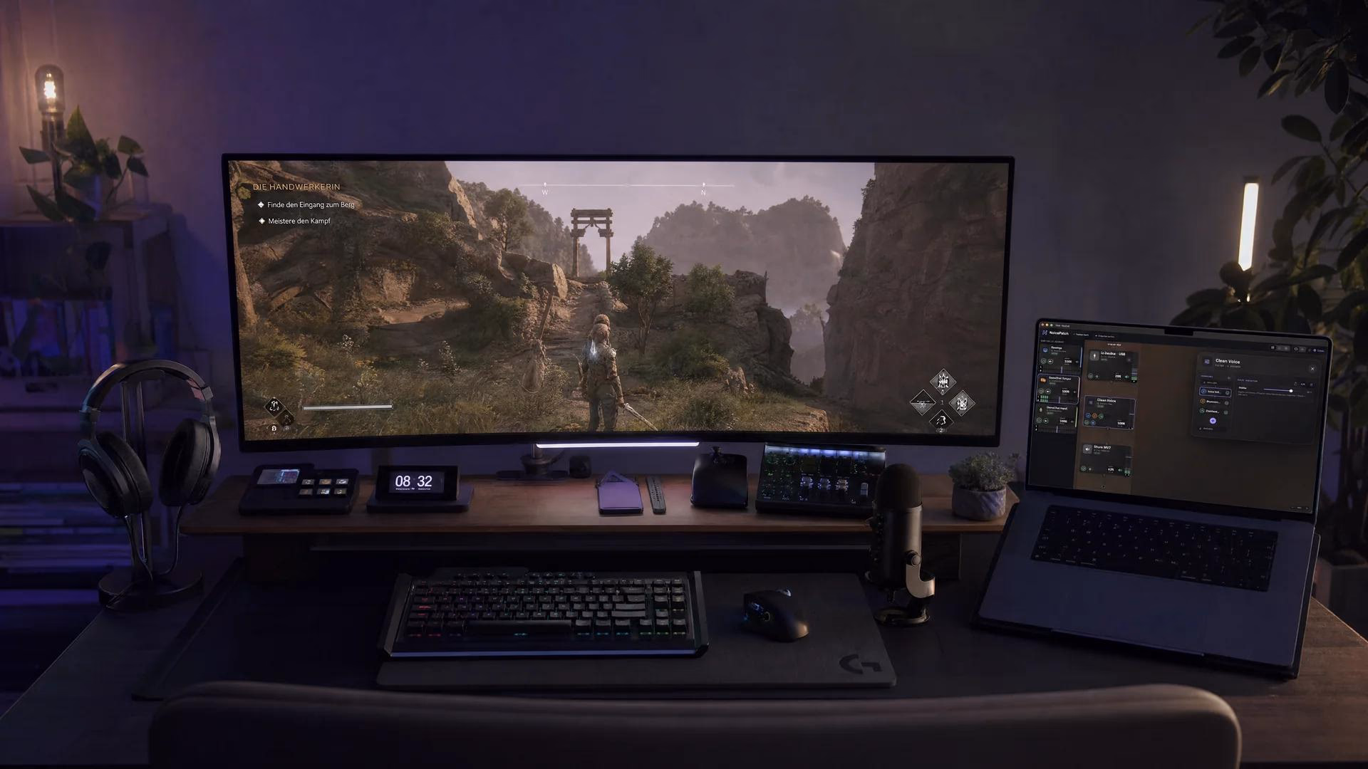 Ultrawide-Monitor mit Spiel, Laptop, Headset und Mikrofon am Schreibtisch