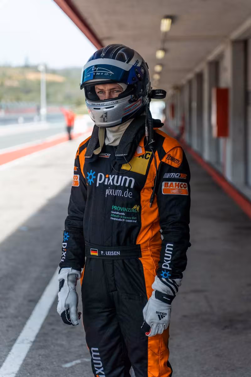 BMW Motorsport: Rennfahrer P. Leisen im Pixum-Rennoverall und Helm in der Boxengasse.
