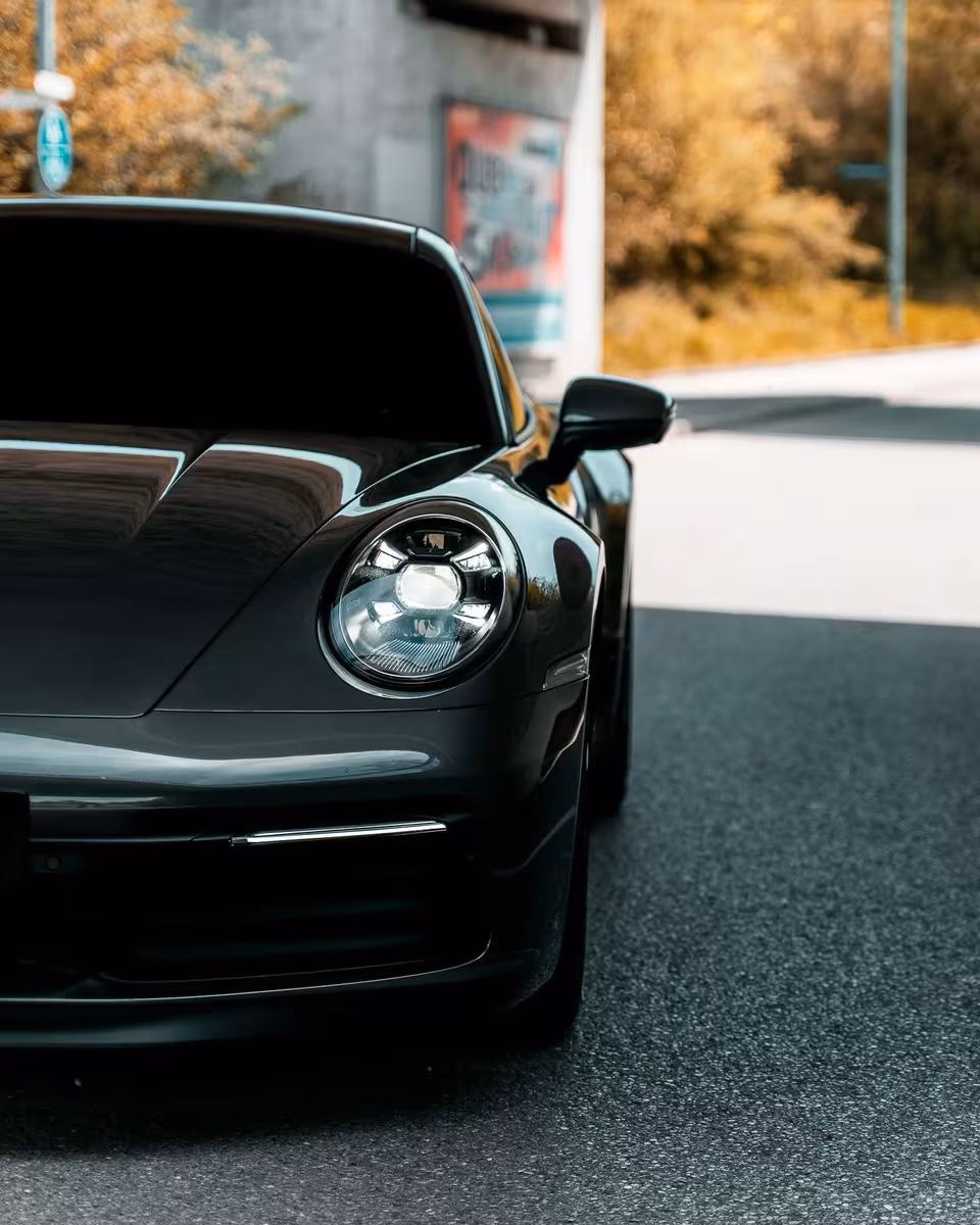 Schwarzer Porsche 911 Carrera 4S, Detailaufnahme der Frontpartie und des runden Scheinwerfers.