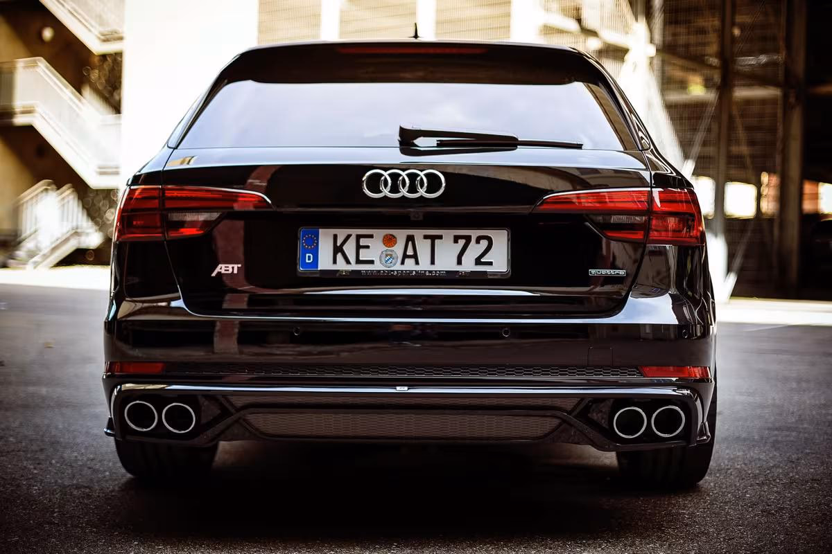 Schwarzer Audi A8 mit ABT-Emblem und vier Auspuffendrohren von hinten