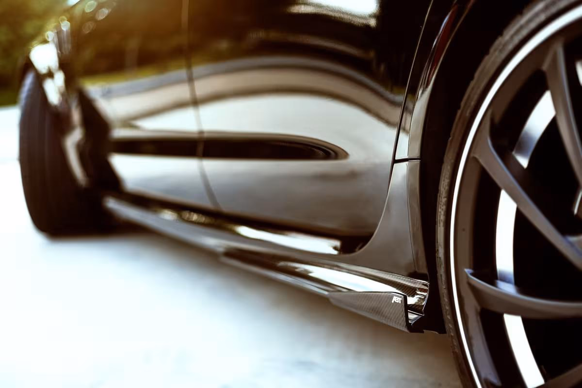 Audi: Nahaufnahme eines schwarzen Sportwagens mit glänzender Karosserie und großem Alufelgenrad.