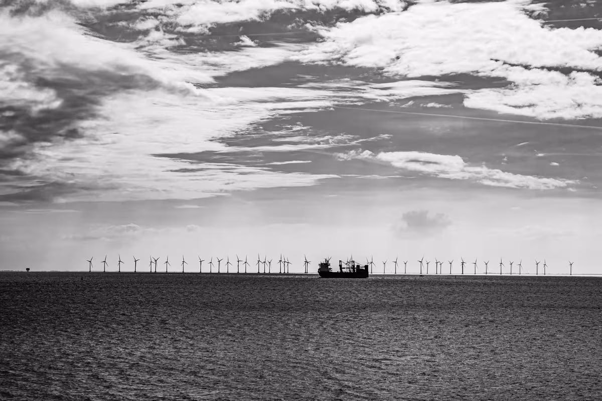 Copenhagen: Schwarz-weißes Foto eines Offshore-Windparks mit Schiff und Wolken