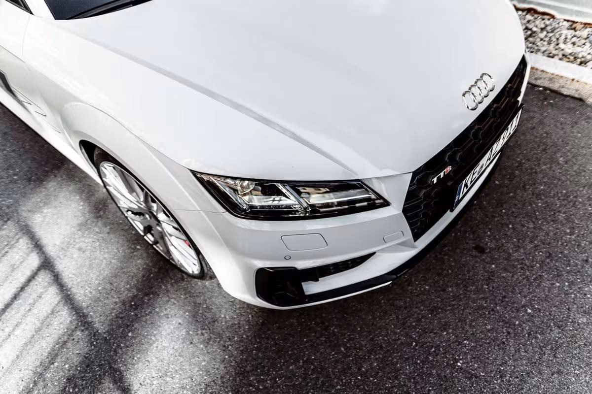 Frontansicht eines weißen Audi TT RS mit sichtbarem Logo und Kennzeichen.