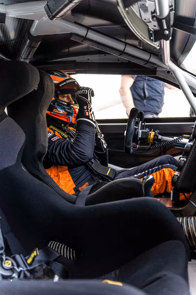 Rennfahrer im BMW Motorsport Cockpit mit Helm und Rennanzug