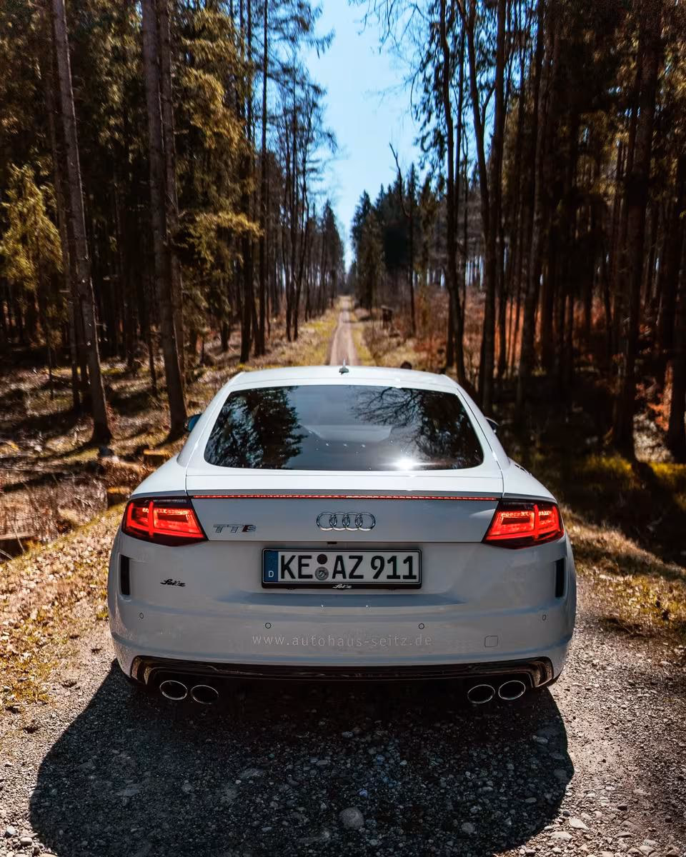 Weißer Audi TT RS von hinten auf einem Waldweg