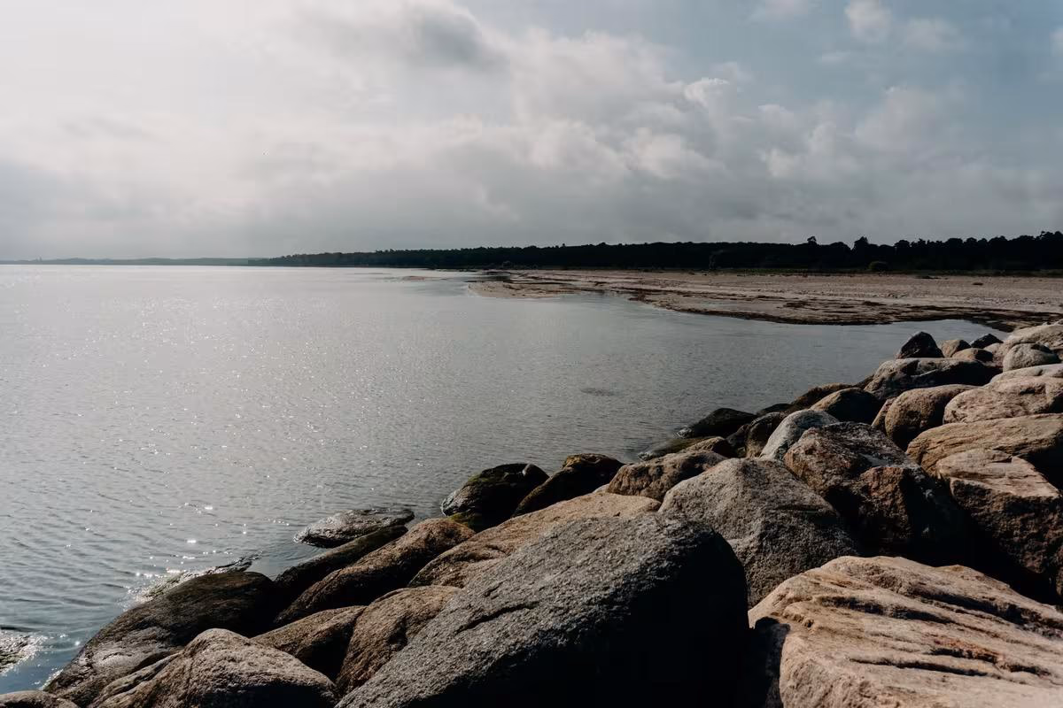 Copenhagen: Felsige Küste mit ruhigem Wasser und bewölktem Himmel
