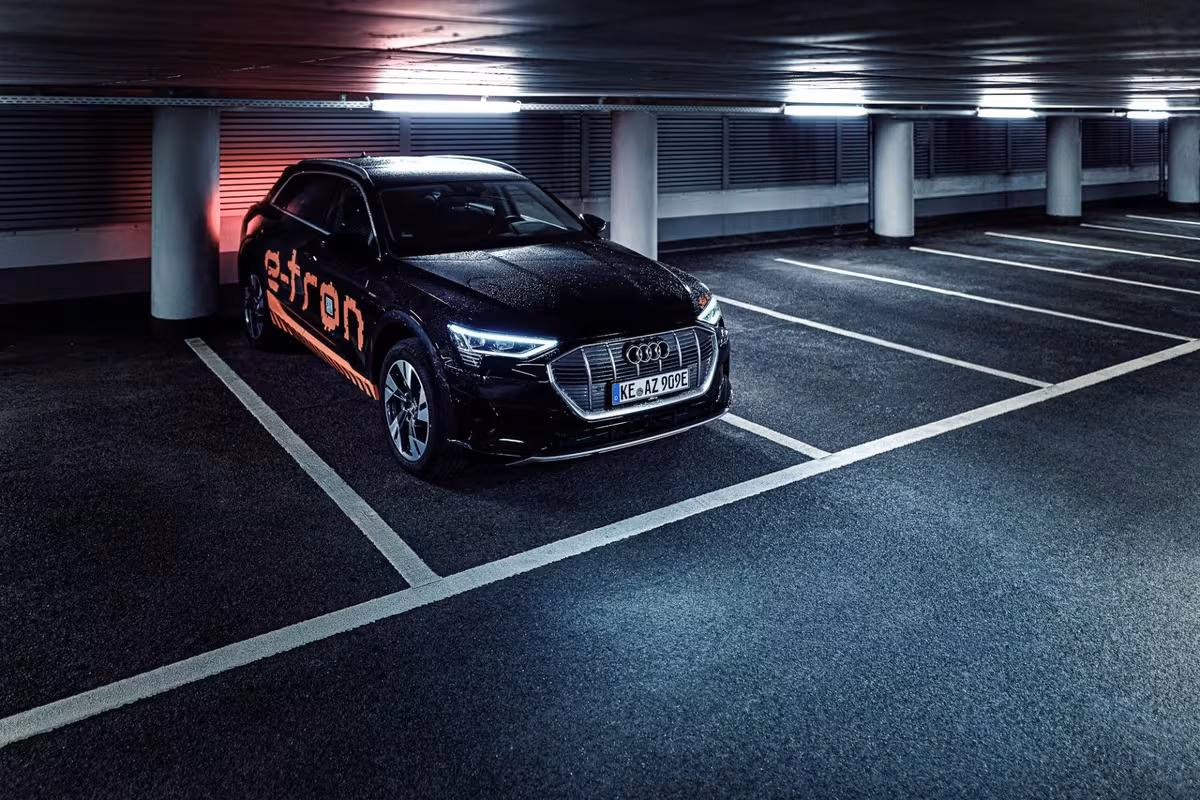 Black Audi e-tron with pixel lighting in a parking garage.