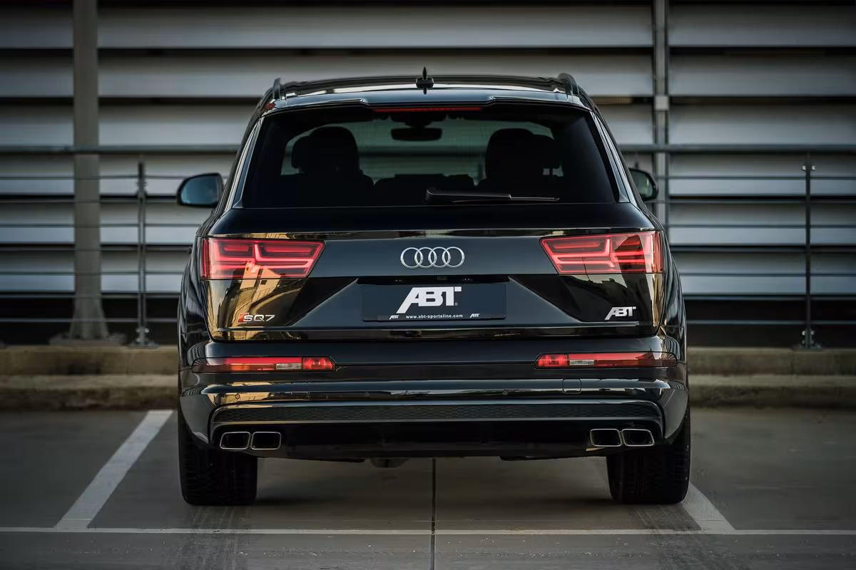 Schwarzer Audi SQ7 mit ABT-Emblemen, Heckansicht im Parkhaus
