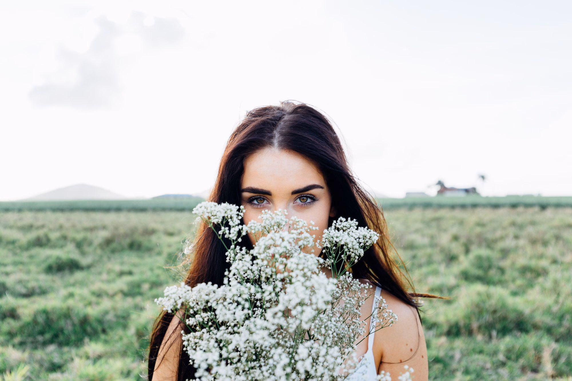 Braut mit Gypsophilen-Bouquet vor grüner Wiese