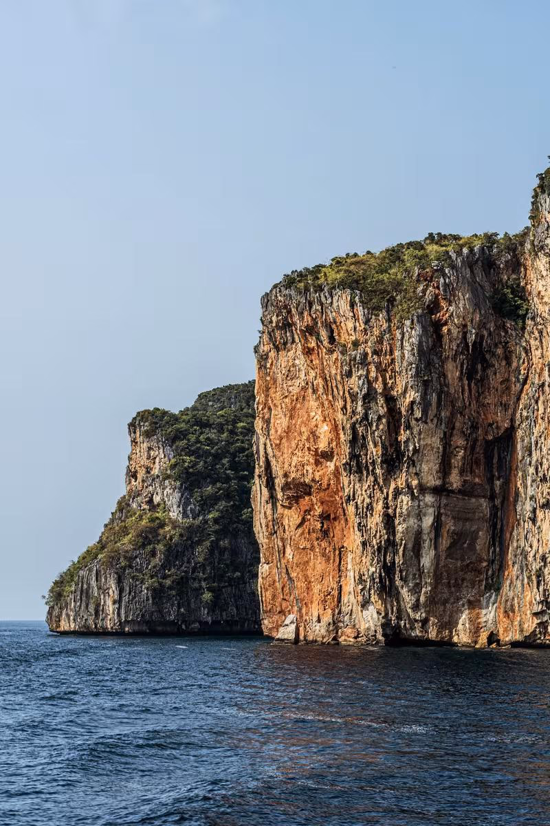 Thailand: Steile, bewachsene Felsklippen ragen direkt aus dem Meer.