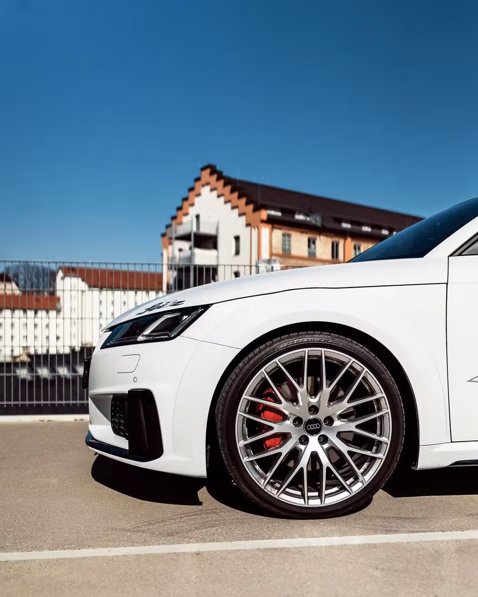 Frontansicht eines weißen Audi RS 7 mit silbernen Felgen und roten Bremssätteln.