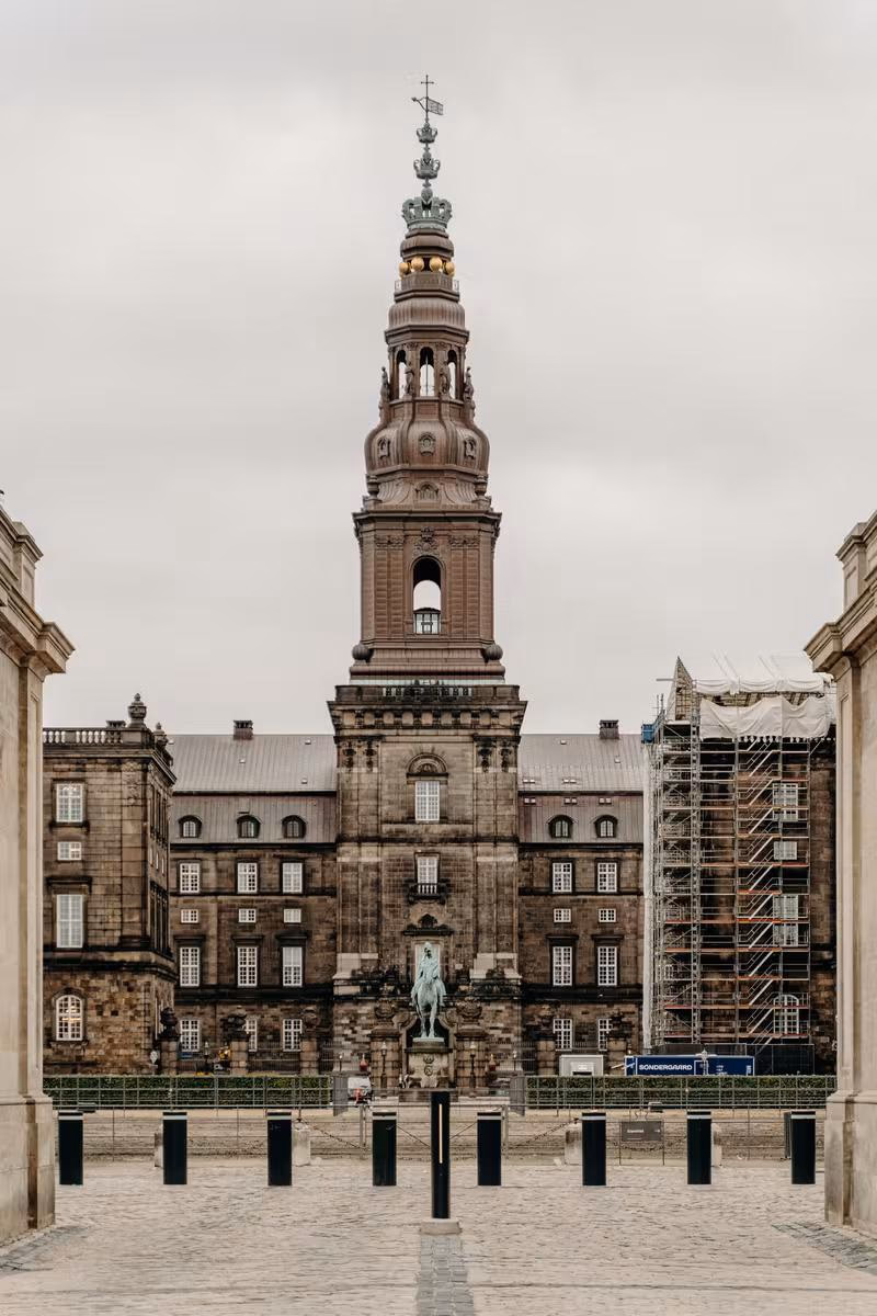 Copenhagen: Historisches Schloss mit hoher Turmspitze, Reiterstandbild und Baugerüst im Innenhof