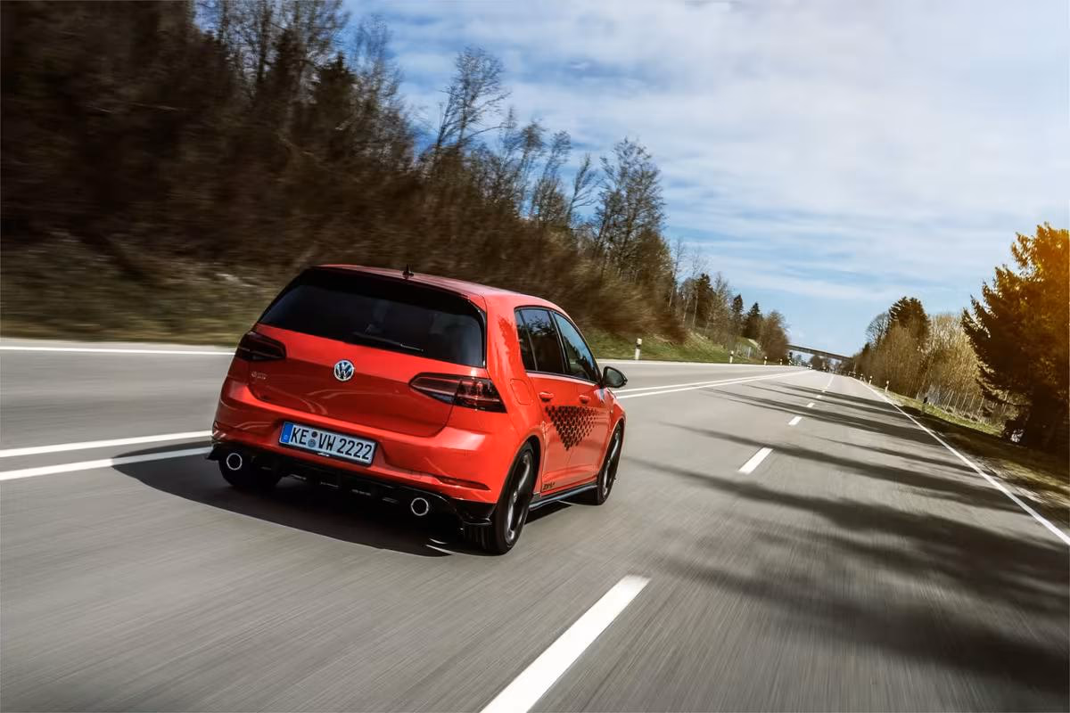 Roter Volkswagen Golf GTI fährt auf einer Landstraße durchs Allgäu.