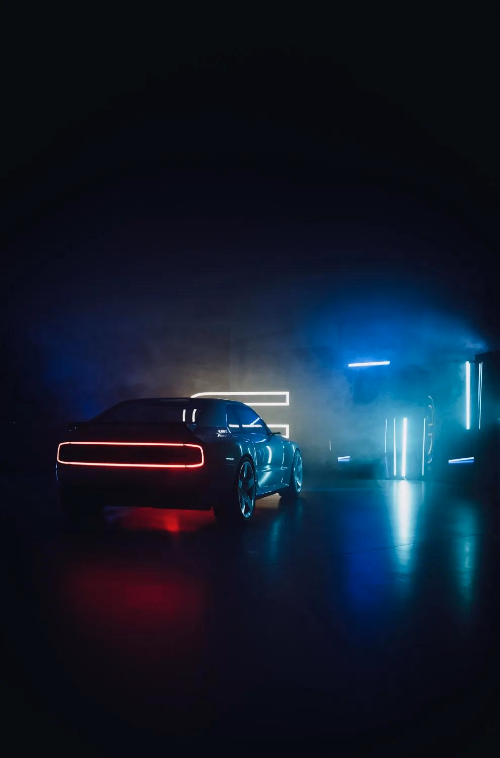 E-Legend: Sportwagen mit rotem Leuchtbalken in dunklem, blau beleuchtetem Raum mit Nebel.