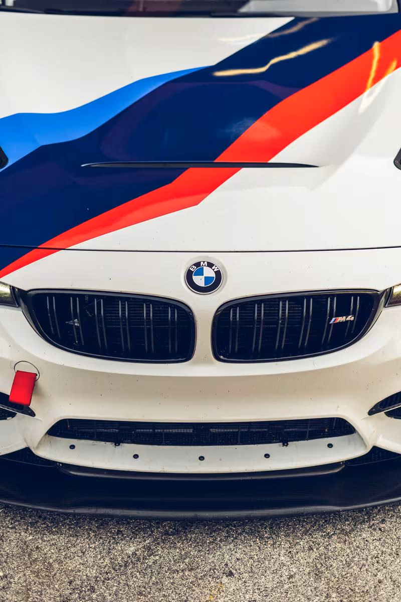 Frontansicht eines BMW M4 mit blau-rot-weißem Motorsport-Lack