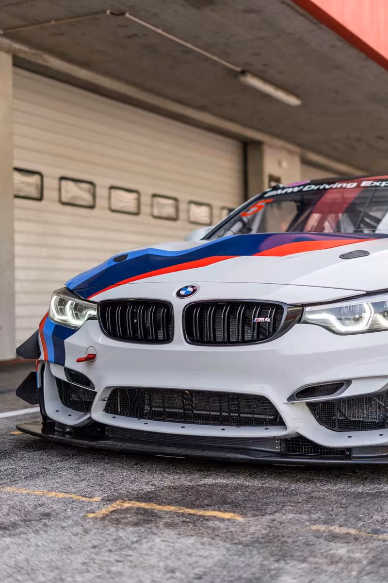 BMW Motorsport: BMW M4 GT3 Rennwagen mit M-Sport-Lackierung vor einer Boxengasse