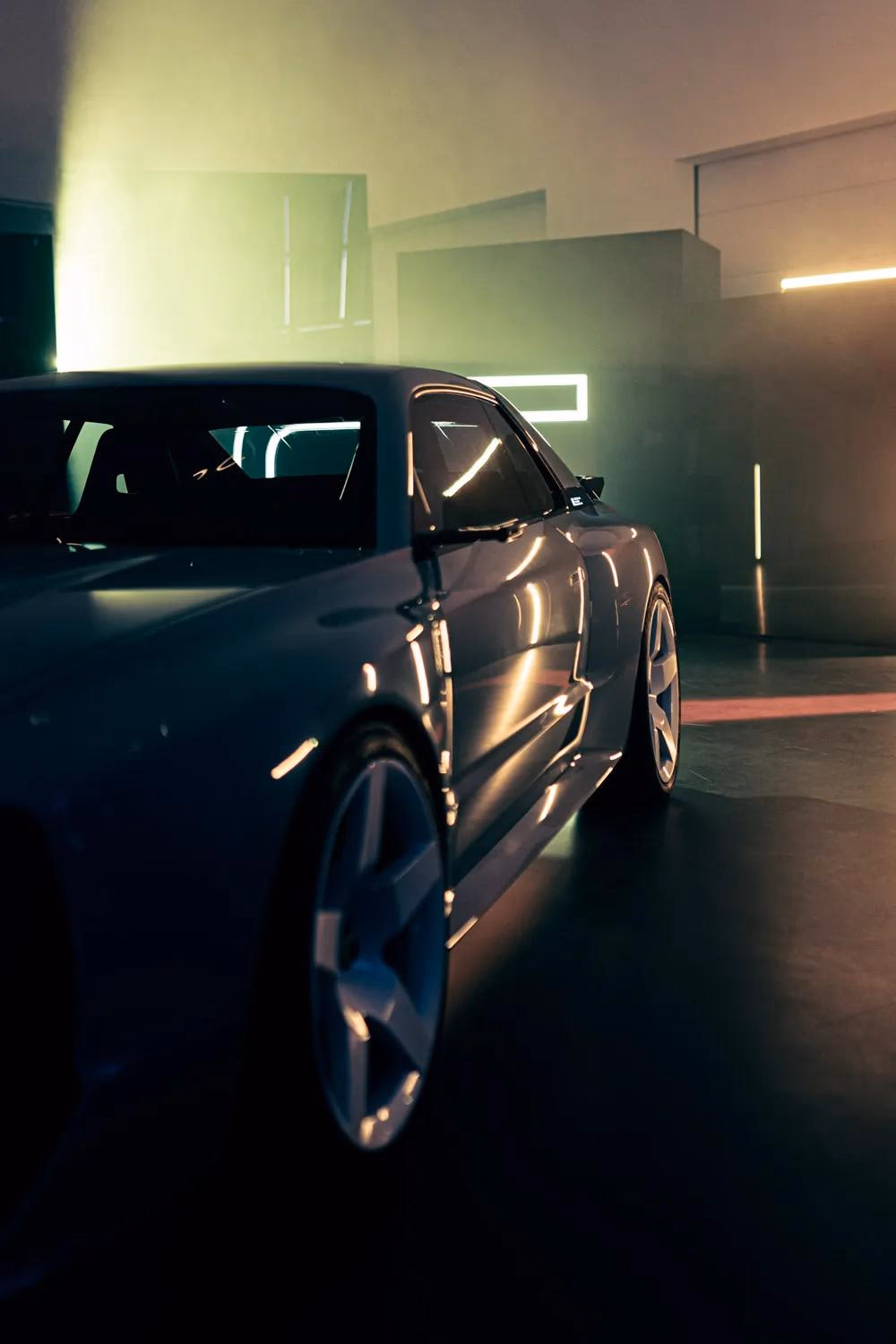 E-Legend: Silhouettierter Sportwagen in dunklem Studio mit grüner und warmer Lichtstimmung.