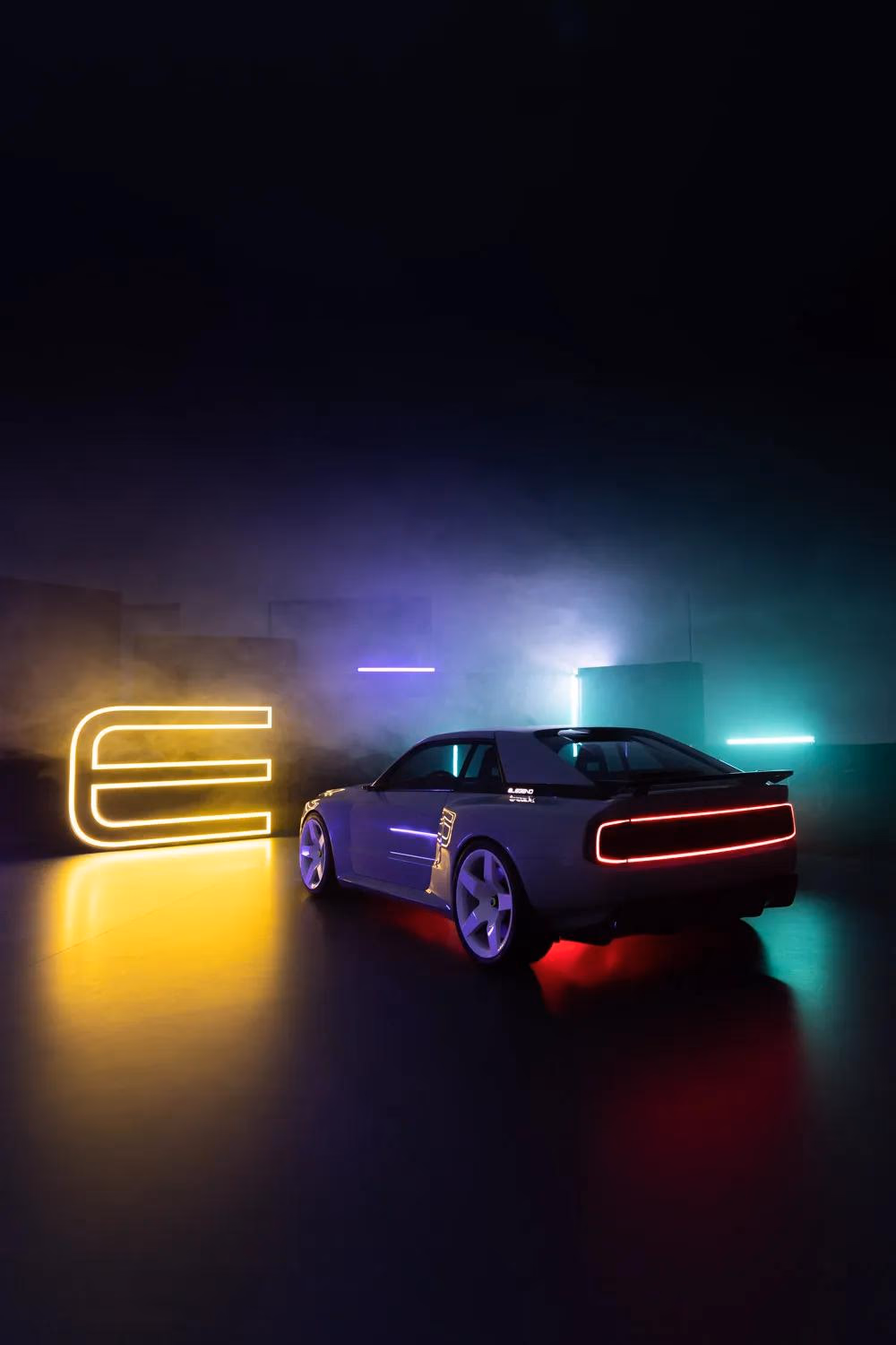 Silhouettierter Sportwagen mit Neonlichtern vor leuchtendem E-Legend-Logo im Nebel.