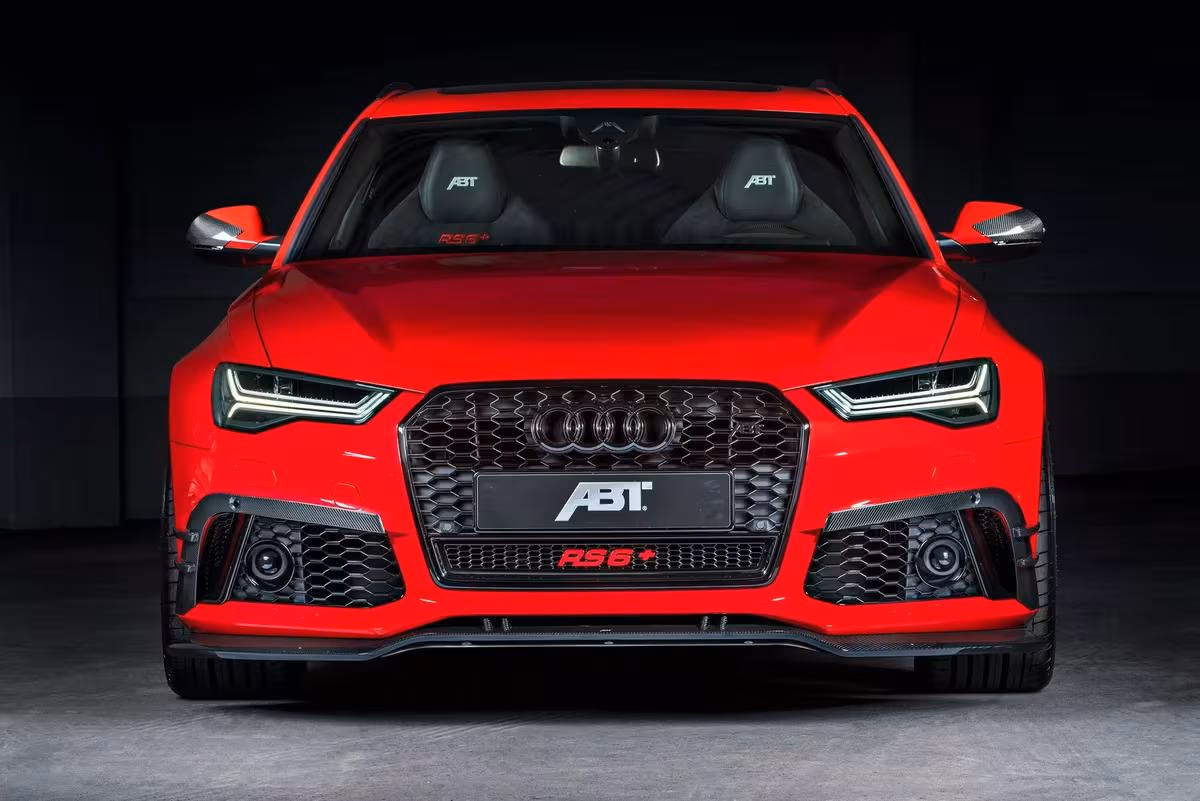 ABT: Rotes ABT RS6+ Coupé frontal vor dunklem Studio-Hintergrund.
