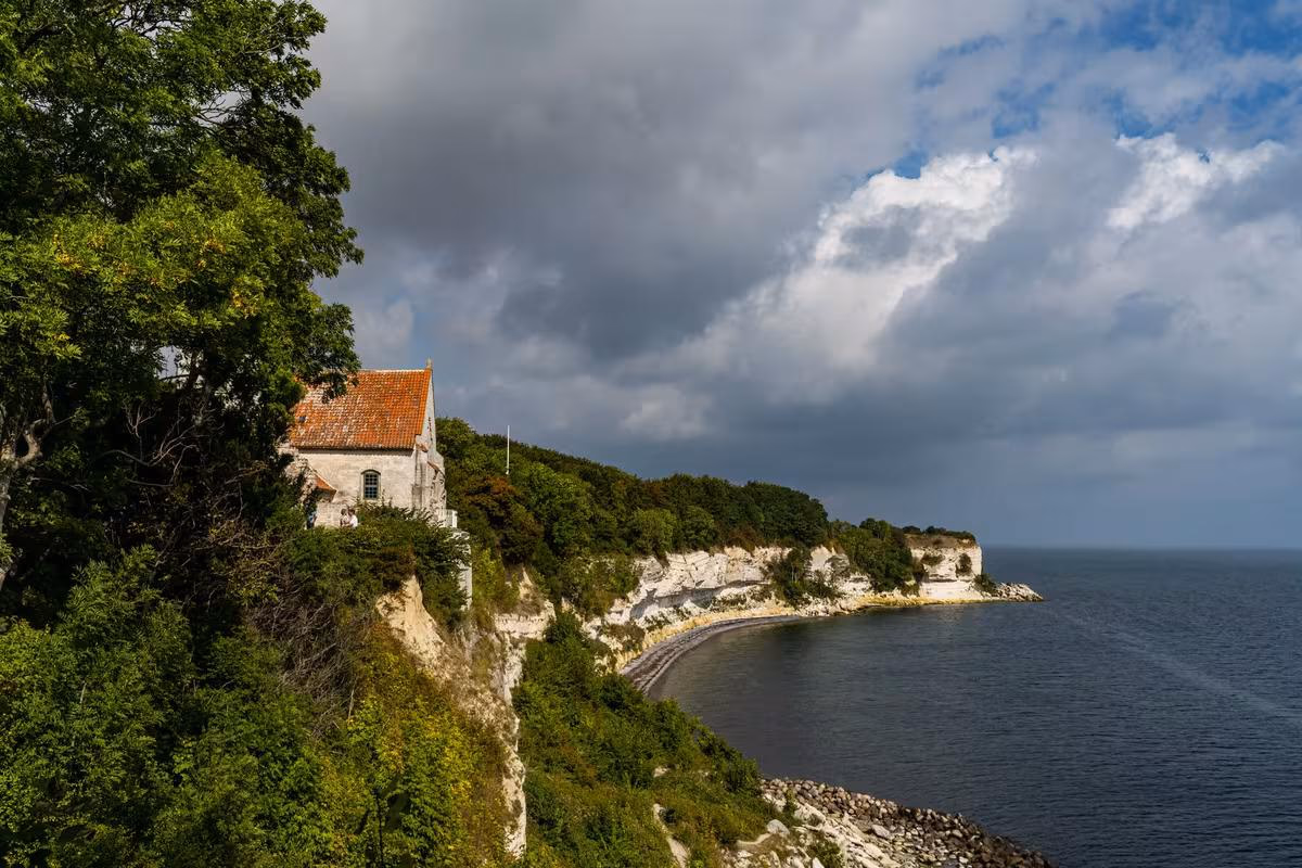 Copenhagen: Kapelle mit rotem Dach auf einer bewaldeten Klippe über dem Meer
